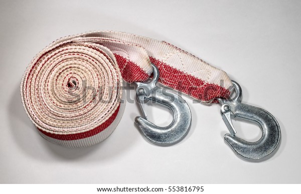 Tow rope to the car on a light background.\
Rope folded in circle hooks are\
nearby.