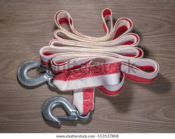 Tow rope for a car on wood\
background. Tow rope elegantly assembled in the center of the\
photo.