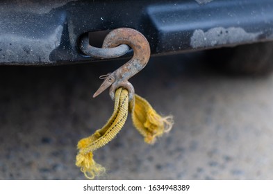 A tow rope with a hook broken during towing. Rusty hook with the rest of the orange cable. Violation of towing rules. Close-up. Selective focus. Without people. Landscape photo arrangement.