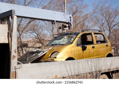 Tow Truck With A Broken Car After An Accident In Its Back.