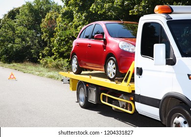 Tow truck with broken car on country road. Space for text