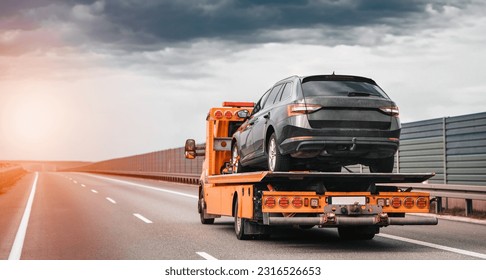 Tow truck with a broken car on a road. Tow truck transporting car on the highway. Car service transportation concept. Roadside Rescue. - Shutterstock ID 2316526653