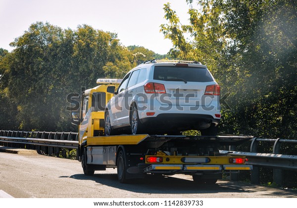 Tow truck with a car on the\
road