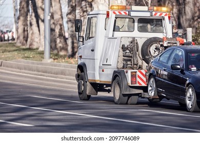 Tow truck carrying improperly parked car or repossessed vehicle.