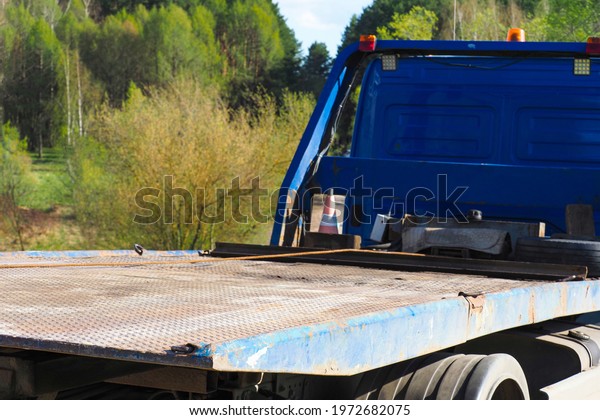 Tow truck close-up. Side rear\
of empty mid size towing truck. Automotive\
transportation
