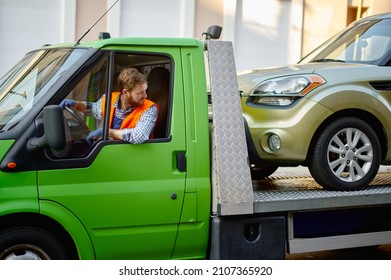 Tow Truck Driver Delivering Car To Autoservice