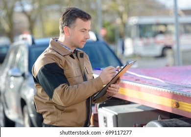 Tow Truck Driver Picking Up Broken Car