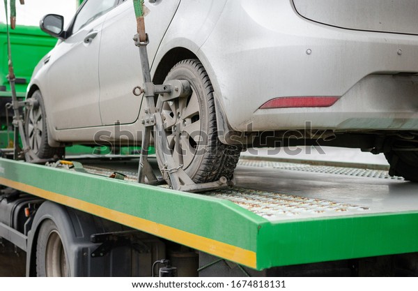 Tow truck lifting the car for improper\
parking. The utility service removes the wrongly parked car.Image\
can be used for topics like traffic\
offense.