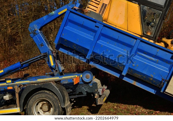 A tow truck loads a\
broken down machine
