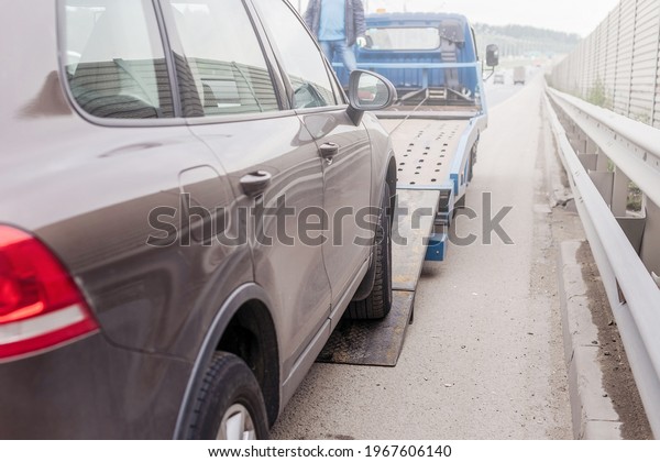  Tow\
truck towing a broken down car on the\
highway