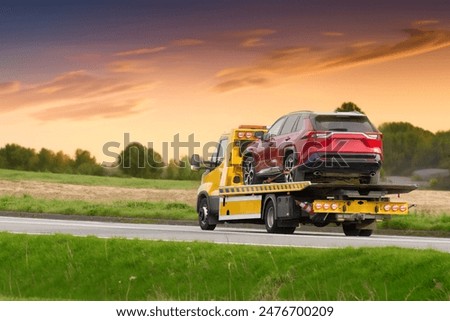 Tow truck towing cars along highway