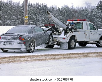 tow truck towing wrecked car in winter