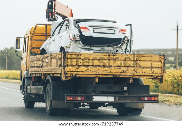 Tow\
truck transport smashed car after traffic accident, help on road\
transports wrecker broken car                   \
