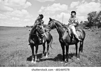 Tow young pretty girls riding a horses on a field at sunny day. - Shutterstock ID 681469378