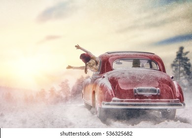 Toward adventure! Happy family relaxing and enjoying road trip. Parent, child and vintage car on snowy winter nature background. Christmas holidays time. 