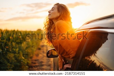 Towards adventure! Young woman is resting and enjoying the trip in the car.  Lifestyle, travel, tourism, nature, active life.