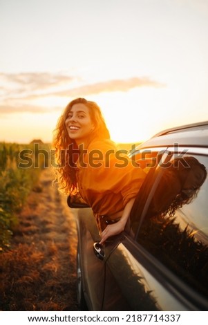Towards adventure! Young woman is resting and enjoying the trip in the car.  Lifestyle, travel, tourism, nature, active life.
