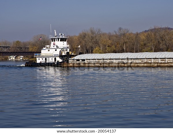 A\
towboat Pushing a barge on the Mississippi\
River.