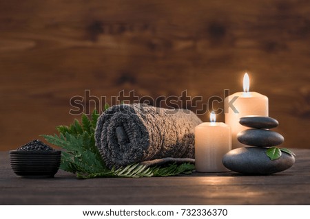Towel on fern with candles and black hot stone on wooden background. Hot stone massage setting lit by candles. Massage therapy for one person with candle light. Beauty spa treatment and relax concept. Zdjęcia stock © 