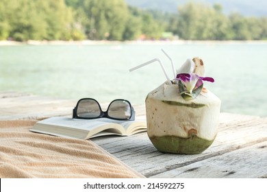 Towel sunglasses book longdrink on pier Koh Samui Thailand