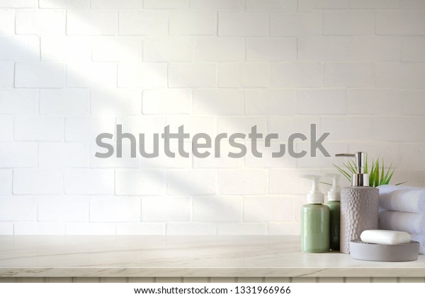 Towels and ceramics shampoo or soap on top\
marble table in bathroom\
background.
