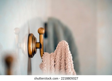 Towels hang on vintage stylish bathroom hooks in light shades.