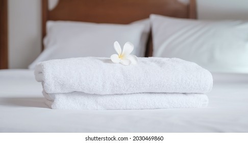 towels and Plumeria on the bed in the luxury hotel room ready for tourist travel.