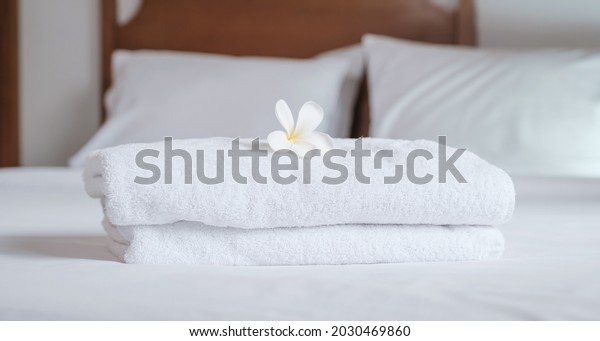 towels and Plumeria on the bed in the luxury\
hotel room ready for tourist\
travel.