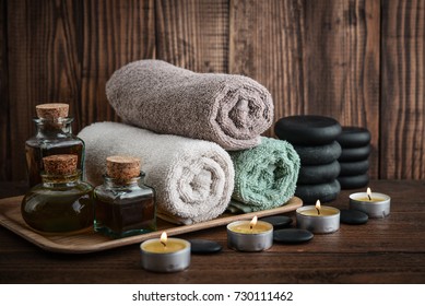 Towels With Sea Salt, Massage Oil In Vintage Bottle, Candles And Stones For Stone Massage On Wooden Background