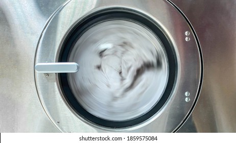 Towels Are Spinning Inside The Front Door Of Stainless Steel Industrial Washing Machine. Shot Taken In The Factory.