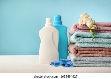 Towels And Washing Powder On Table On Blue Background.