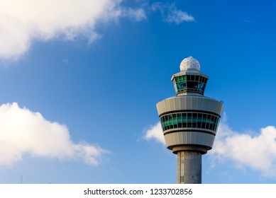 The tower in airport in Amsterdam. The tower against blue cloudy sky. Control tower in airport. Aviation observation post in airport in Netherlands.