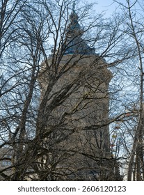 A tower behind the branches of bare trees in early spring.