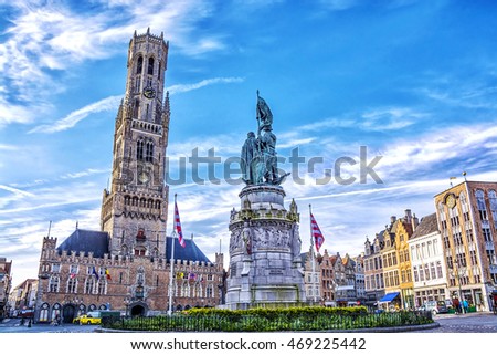 Tower Belfort and colorful old brick house on the Grote Markt square in the medieval town of Bruges, Belgium