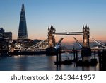 Tower Bridge illuminated at night, with the bridge raised over the River Thames, London, England, United Kingdom, Europe