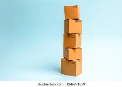 Tower of cardboard boxes on a blue background. The concept of moving and delivery of goods and products. Commerce and business processes, logistics, distribution and sales. - Shutterstock ID 1246971859