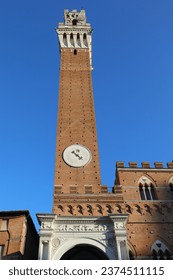 Tower with clock called TORRE DEL MANGIA in the city of Siena in central Italy without people