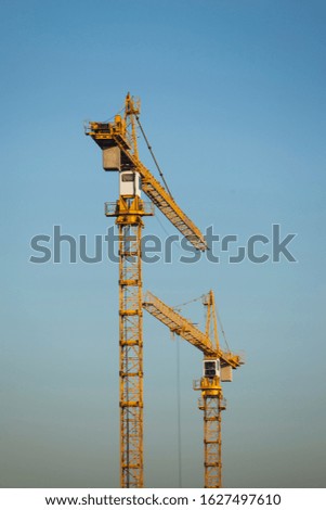 Tower construction cranes against the background of the blue sky
