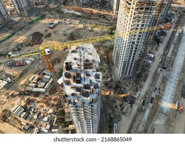 Tower crane on building construction, top view. Builder on formworks. Possible granularity, motion blur. 