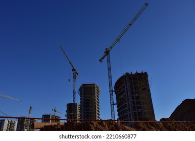 Tower Crane On Construction. Сonstruction Site With Tower Cranes On Building Construction. Builder On Formworks. Cranes On Pouring Concrete In Formwork.  Built Environment. Buildings Renovation.
