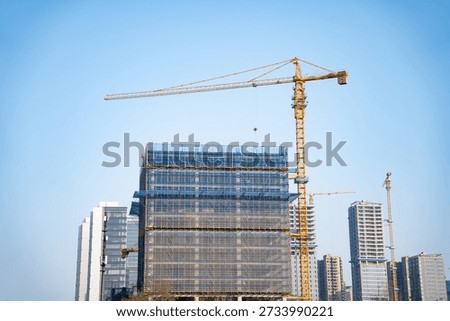 Tower crane operating above under-construction high-rise building