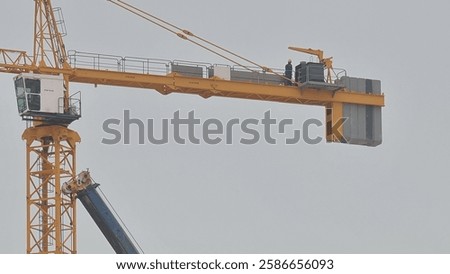 A tower crane operator skillfully maneuvers heavy loads, ensuring safe and efficient construction at towering heights.