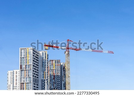 Tower cranes on the construction site of a block of flats of the monolithic residential apartment building