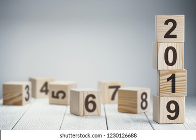 Tower of four wooden cubes symbolizing year 2019 on neutral background with copy space