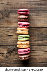 A tower from french colorful macarons on a woody background