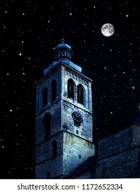 Tower Of The Gothic Church Against A Background Of Night Sky With Stars And Full Moon