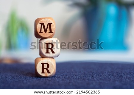 Tower made of cubes and dice with acronym MRR - monthly recurring revenue