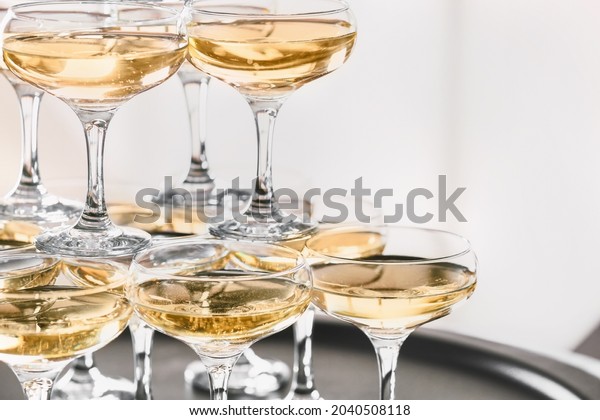 Tower\
made of glasses with champagne on table,\
closeup