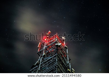Tower for mobile communication systems 4g and 5g on the background of the starry sky. Cellular base station at night