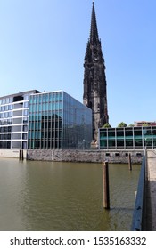 The tower of the St. Nicholas, or Nikolaikirche church rising above modern offices in Hamburg, Germany